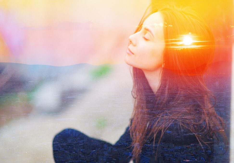 Double multiply exposure portrait of a dreamy cute woman meditating outdoors with eyes closed, combined with photograph of nature, sunrise or sunset. closeup. Psychology power of mind concept.